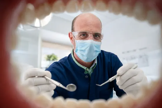 Dr. Luis Gross Schweller com equipamentos de proteção durante atendimento odontológico
